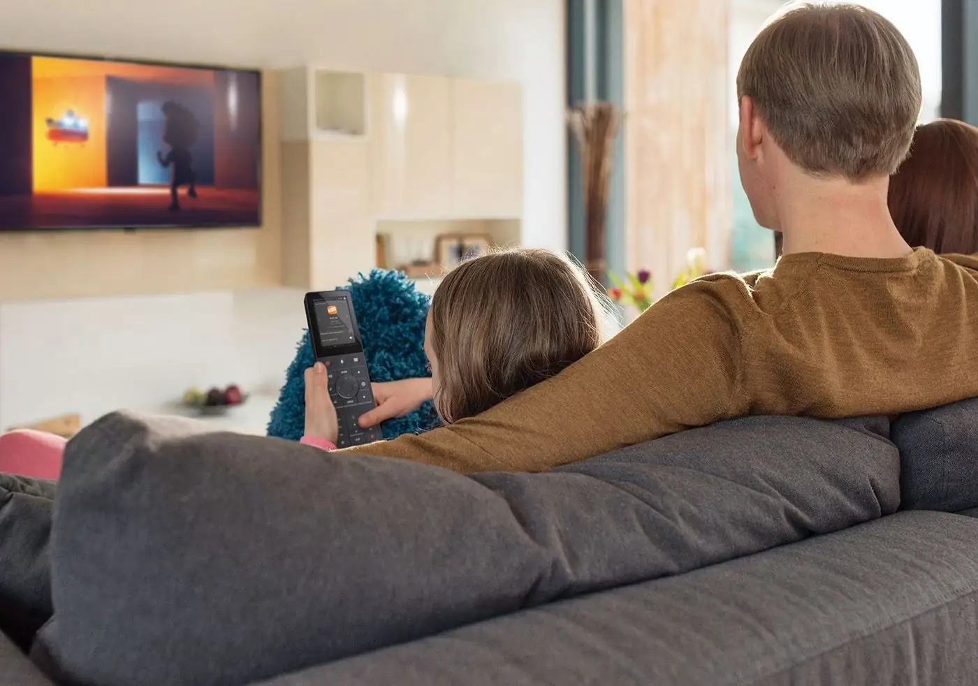 Family watching a large screen in a living room